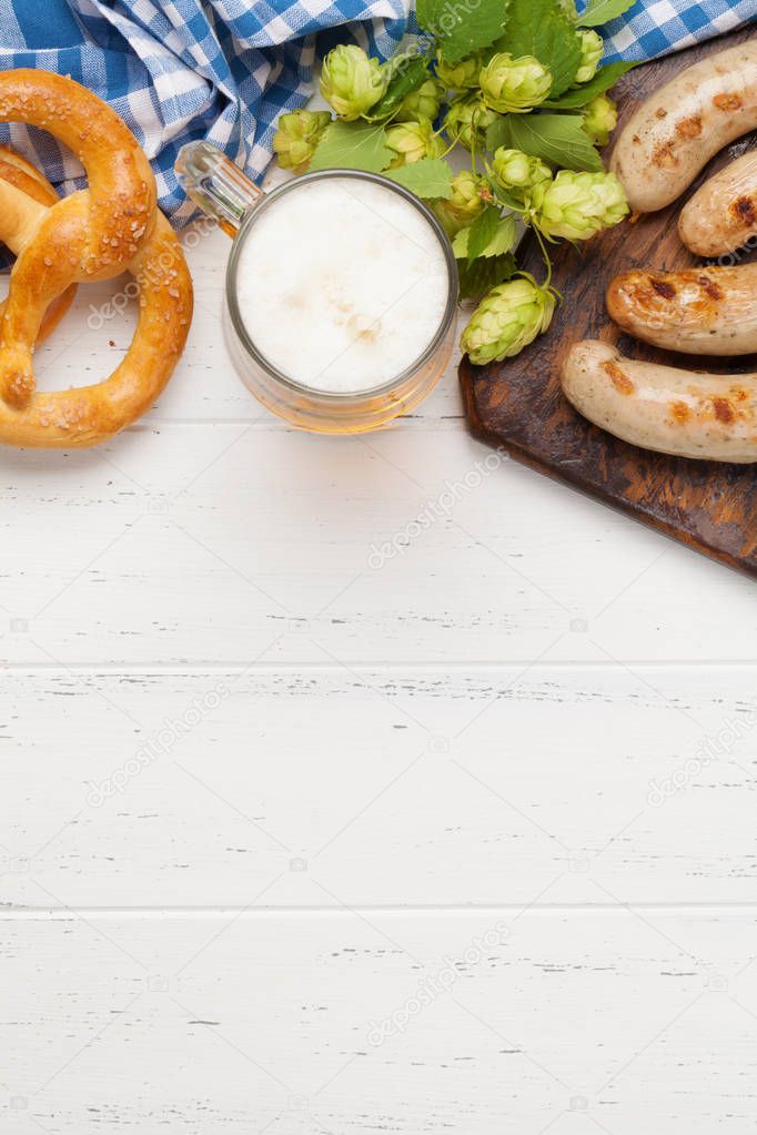 Oktoberfest set. Pretzels, sausages, meat and lager beer mug on wooden background. With copy space. Top view flat lay