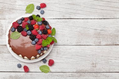 Çilekli çikolatalı kek. Kopya alanı olan ahşap masada. Üst görünüm düzlüğü