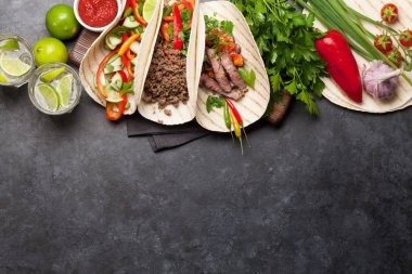 Tortilla 'da etli ve sebzeli Meksika tacoları. Ve Caipirinha kokteyli. Taş masadaki en üst manzara. Kopyalama alanı olan düz