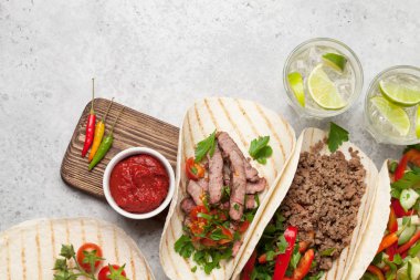 Tortilla 'da etli ve sebzeli Meksika tacoları. Ve Caipirinha kokteyli. Taş masadaki en üst manzara. Kopyalama alanı olan düz