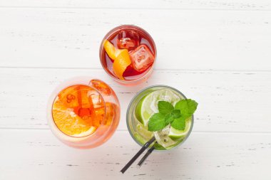 Tahta masada üç klasik kokteyl bardağı. Negroni, aperol spritz ve mojito. Kopyalama alanı olan üst görünüm