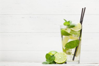 Ahşap masada klasik kokteyl camı. Limonlu ve naneli mojito. Kopyalama alanı ile