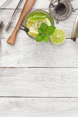 Kokteyl tabakları. Ahşap masada bar aletleri ve mojito kokteyli. Üst görünüm düzlüğü kopyalama alanı ile yatıyordu