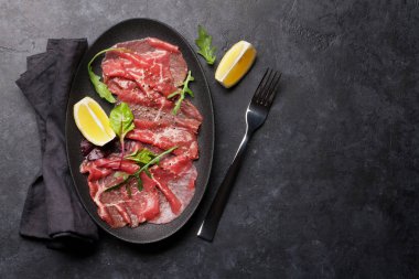 Arugula, limon ve biberli mermer sığır carpaccio. Üst görünüm, kopyalama alanı olan düz uzanma