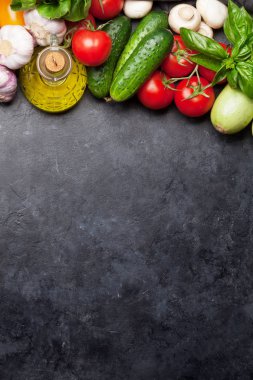 Çeşitli çiğ organik sebzeler, otlar ve baharatlar. Taze bahçe vejetaryen gıda. Kopya alanı olan taş masada üst görünüm