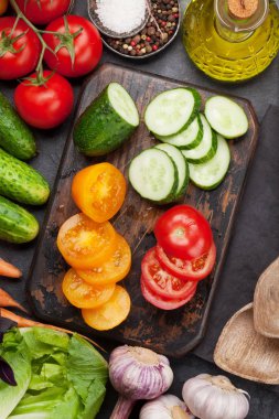 Çeşitli çiğ organik sebzeler, otlar ve baharatlar. Taze bahçe vejetaryen yemek pişirme. Taş masaüzerinde üst görünüm