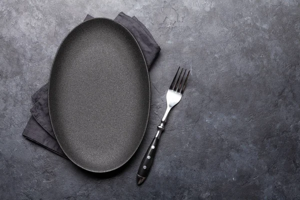 Empty plate and fork on stone table. Food template concept. Top view with copy space. Flat lay