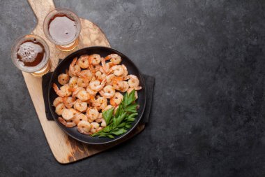 Taslak bira ve taş arka plan üzerinde aperatifler. Izgara karidesler. Kopyalama alanı ile üstte görünüm