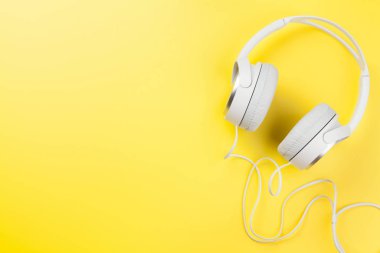 Sarı arka planda müzik kulaklıkları. Ses konsepti. Kopyalama alanı ile üst görünüm. Düz yatıyordu
