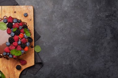 Çikolatalı pasta ya da çilekli cheesecake. Kopya alanı olan taş masanın üzerinde. Üst görünüm düzlüğü