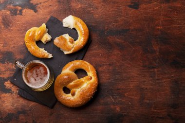 Oktoberfest seti. Ahşap arka planda krakerler ve bira bardağı. Kopyalama alanı olan üst görünüm. Düz yatıyordu