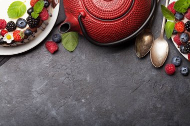 Çikolatalı kek ve çilekli cheesecake ve çay. Kopya alanı olan taş masanın üzerinde. Üst görünüm düzlüğü