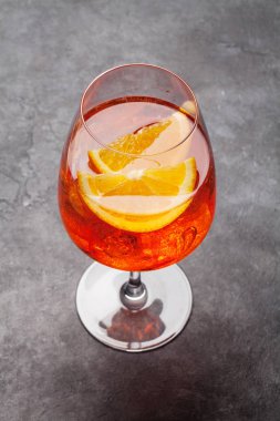 Aperol spritz kokteyl bardağı taş masanın üstünde.