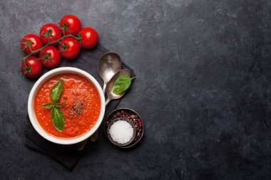 Olgun domates, salatalık ve fesleğen ile soğuk gazpacho çorbası taş masada. Üst görünüm düz kopyalama alanı ile yatıyordu