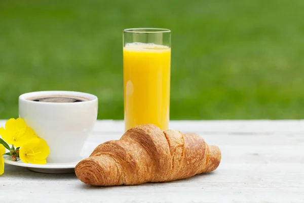 日当たりの良い庭のテーブルの上にコーヒー オレンジジュース クロワッサン フランスの朝食 テキストのコピースペースを持つ — ストック写真