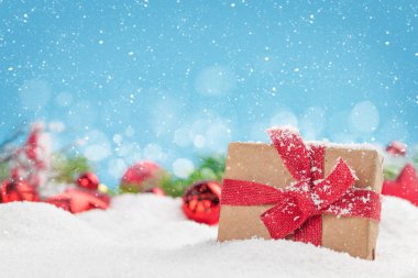 Hediye kutusu ve karla kaplı Noel tebrik kartı mavi arka planda ve Noel kutlamalarınız için alanı kopyalayın.