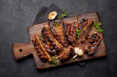 Tahtada dilimlenmiş barbekü bifteği ve bbq sosu. Üst görünüm düzlüğü