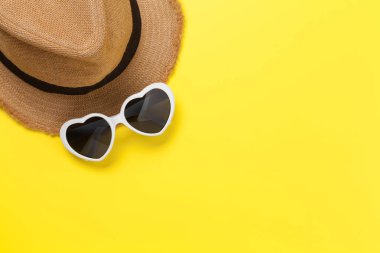 Güneş şapkası ve kalp şeklinde güneş gözlükleriyle seyahat konsepti. Üst görünüm düzlüğü kopyalama alanı ile yatıyordu