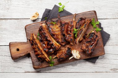 Tahtada dilimlenmiş barbekü bifteği ve bbq sosu. Üst görünüm düzlüğü
