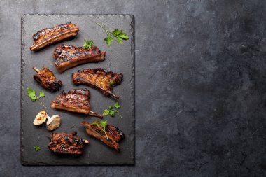 Taş bir tahtada dilimlenmiş barbekü bifteği ve bbq sosu. Üst görünüm düzlüğü kopyalama alanı ile yatıyordu