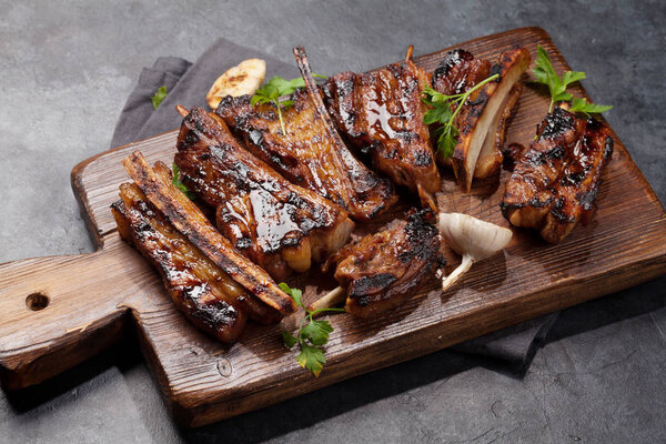 Barbecue beef ribs with bbq sauce sliced on a wooden board