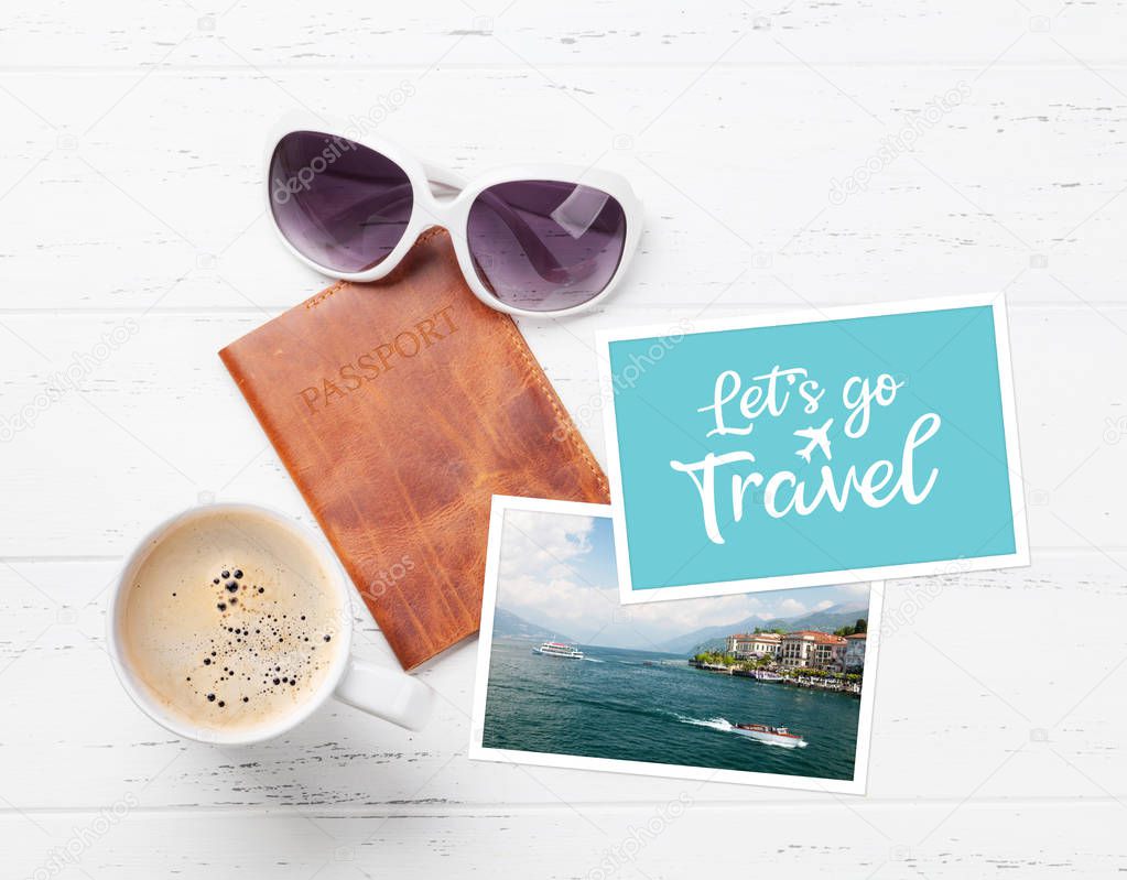 Travel vacation concept with passport, coffee cup, photos and sunglasses on wooden backdrop. Top view with copy space. Flat lay