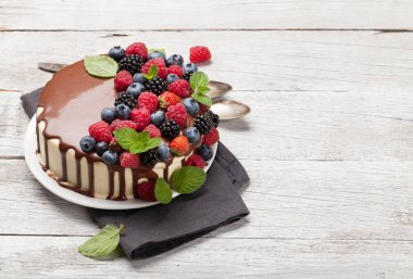 Çikolatalı pasta ya da çilekli cheesecake. Kopya alanı olan ahşap masanın üzerinde