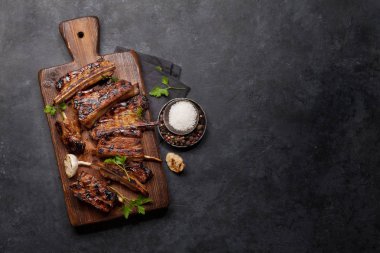 Tahtada dilimlenmiş barbekü bifteği ve bbq sosu. Üst görünüm düzlüğü kopyalama alanı ile yatıyordu
