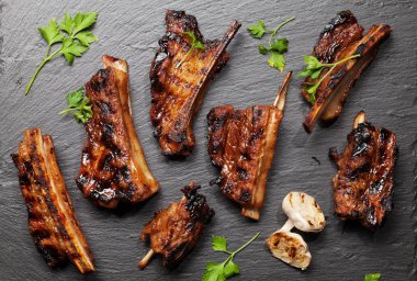 Taş bir tahtada dilimlenmiş barbekü bifteği ve bbq sosu. Üst görünüm düzlüğü