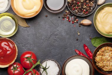 Çeşitli soslar var. Popüler soslar, ketçap, hardal, mayonez ve koyu taş masa. Kopyalama alanı olan üst görünüm. Düz yatıyordu