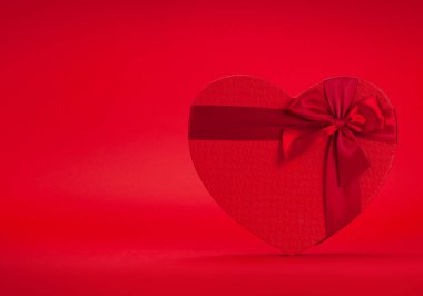 Sevgililer Günü hediye paketi kırmızı arkaplanda. Selamlarınız için fotokopi alanı da var.