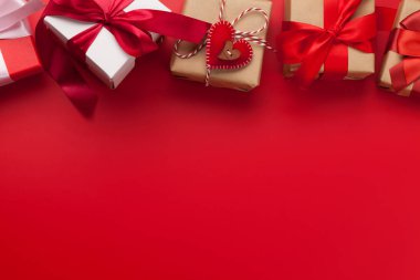 Sevgililer Günü hediye kutuları kırmızı arka planda. Selamlarınız için fotokopi alanı da var. Üst görünüm düzlüğü