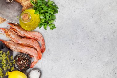 Taze deniz ürünleri. Langostino karidesleri, taş zeminüzerinde otlar ve baharatlar. Üst görünüm düz yatıyordu. Metniniz için kopyalama alanı ile