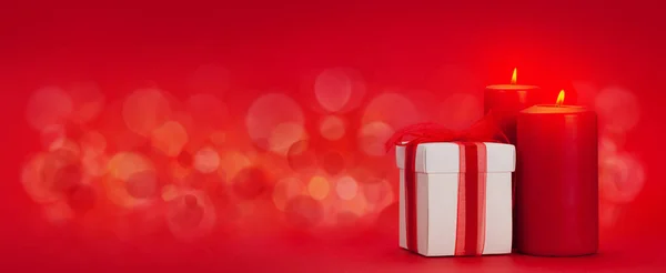 Valentijnsdag Wenskaart Met Geschenkdoos Brandende Kaarsen Rode Achtergrond Met Kopieerruimte — Stockfoto