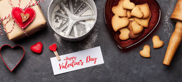 Валентинов день подарочная коробка и сердце форме пряников печенье на каменном фоне с поздравительной открыткой. Квартира с видом сверху
