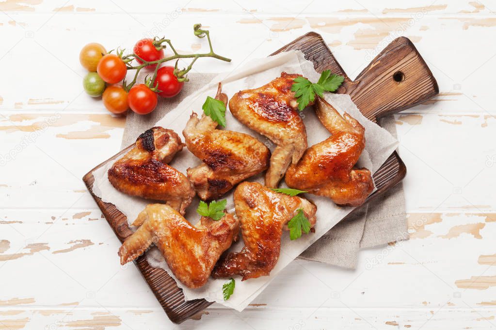 Hot barbecue chicken wings with sauce. Top view on wooden table