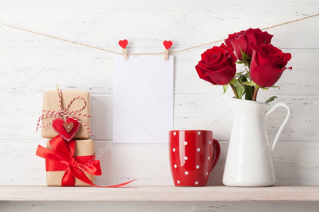 Valentines day greeting card with rose flowers and gift boxes on white wooden background. With space for your greetings