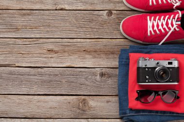 Giysiler ve aksesuarlar. Spor ayakkabı, kot pantolon, kamera ve güneş gözlüğü. Her gün için şehir kıyafeti ya da arka planda fotokopi alanı olan bir seyahat tatili. Üst görünüm düzlüğü