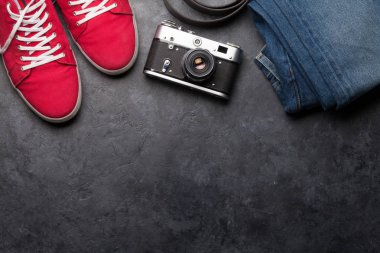 Giysiler ve aksesuarlar. Spor ayakkabı, kot pantolon ve kamera. Her gün için şehir kıyafeti ya da arka planda fotokopi alanı olan bir seyahat tatili. Üst görünüm düzlüğü