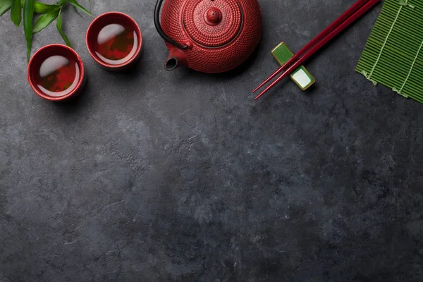 Zelený Čaj Miskách Konvice Sushi Hůlky Kamenném Stole Horní Pohled — Stock fotografie