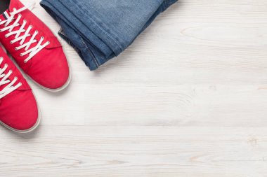 Giysiler ve aksesuarlar. Spor ayakkabı ve kot pantolon. Her gün için şehir kıyafeti ya da arka planda fotokopi alanı olan bir seyahat tatili. Üst görünüm düzlüğü