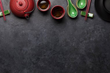 Japon çayı, çorba kaşıkları ve yemek çubukları taş masada. Asya yemekleri konsepti. Üst görünüm düzlüğü kopyalama alanı ile yatıyordu