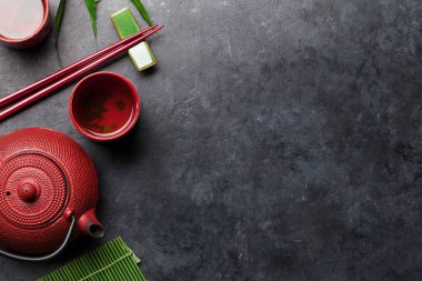 Japon çayı ve çubukları taş masada. Asya yemekleri konsepti. Üst görünüm düzlüğü kopyalama alanı ile yatıyordu
