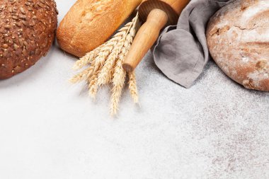 Taş masada çeşitli ekmek ve yemek malzemeleri var. Kopyalama alanı ile