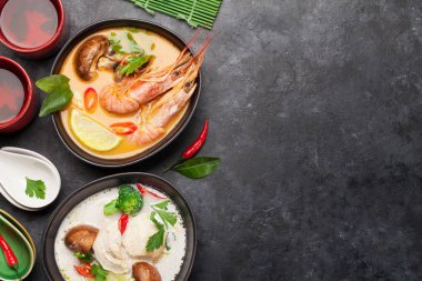 Tom Yum ve Tom Kha geleneksel deniz ürünleri, tavuk, mantar, hindistan cevizi sütü ve sıcak baharatlı Tayland çorbaları. Yeşil çayla. Kopyalama alanı olan üst görünüm