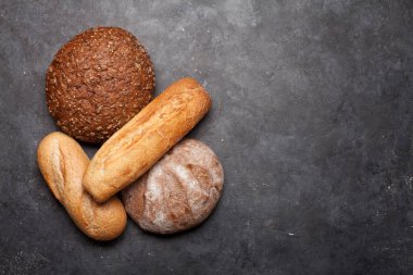 Taş masada çeşitli ekmekler. Üst görünüm düzlüğü kopyalama alanı ile yatıyordu