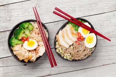Tavuklu, sebzeli ve ahşap kaplama yumurtalı Asya erişteli ramen çorbası. Üst görünüm düzlüğü