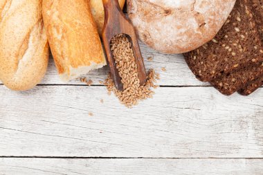 Tahta masada çeşitli ekmekler. Üst görünüm düzlüğü kopyalama alanı ile yatıyordu