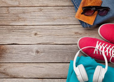 Giysiler ve aksesuarlar. Spor ayakkabı, kot pantolon ve kulaklık. Her gün için şehir kıyafeti ya da arka planda fotokopi alanı olan bir seyahat tatili. Üst görünüm düzlüğü