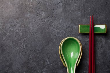 Japon çorba kaşıkları ve yemek çubukları taş masada. Asya yemekleri konsepti. Üst görünüm düzlüğü kopyalama alanı ile yatıyordu